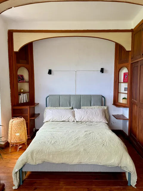 A closer view of the bedroom's arched wood-panelled bed nook
