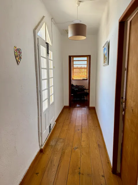 Hallway leading from bedroom to a sitting room, with wood floors throughout