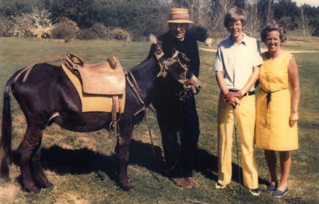 Henry Cotton with his donkey caddie Pacífico and two companions on a golf course lawn, 1970